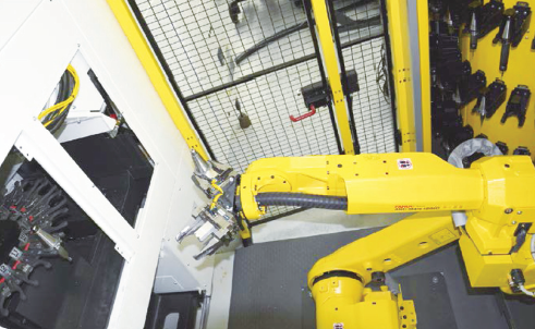 Fanuc 公司的一个六轴机械手正在从柱形刀库中取出刀具更换到机器的 工作圆盘上。（图源：Hanser）